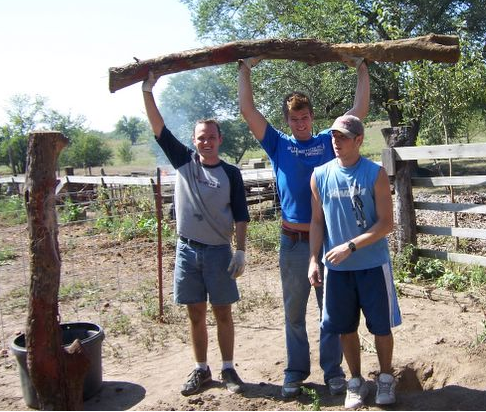 Man conquers fence post